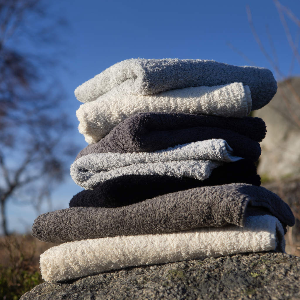 Stack of folded towels on a rock with a blue sky background