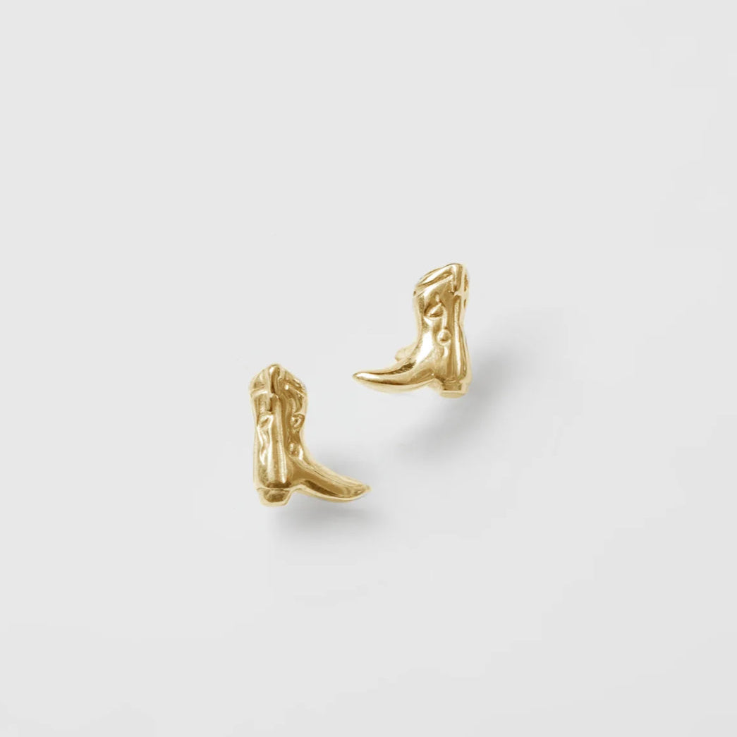 A pair of gold-plated brass cowboy boot stud earrings on a white background.