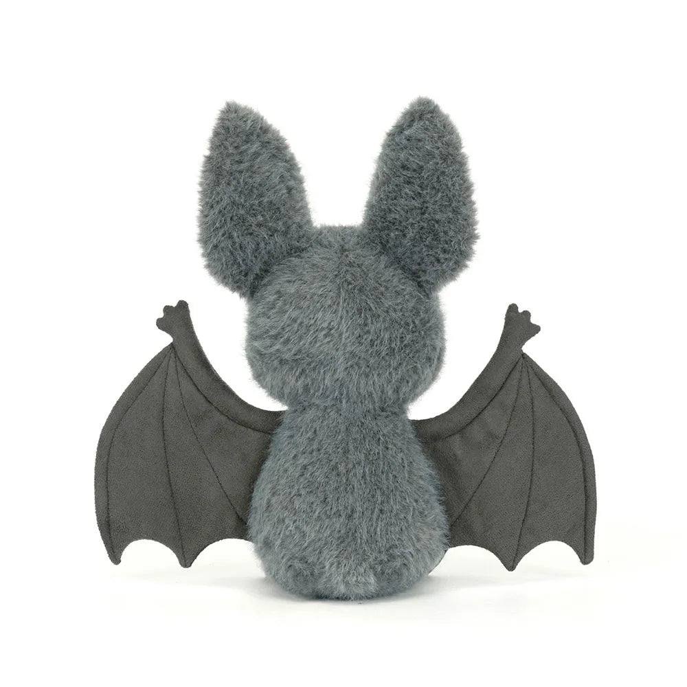 Plush toy bat with gray fur and black wings on a white background