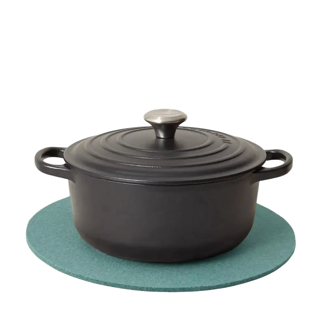 Graf Lantz Merino Wool Round Trivet in Spruce, with a cast Iron french oven on top