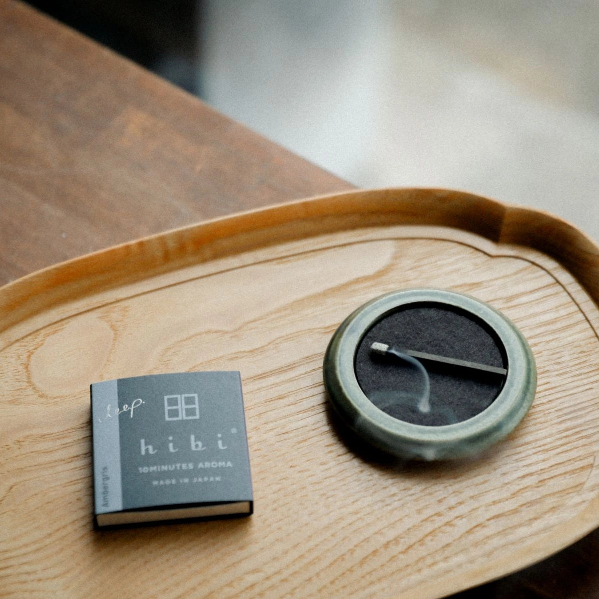 Hibi round incense tray in green on wooden table