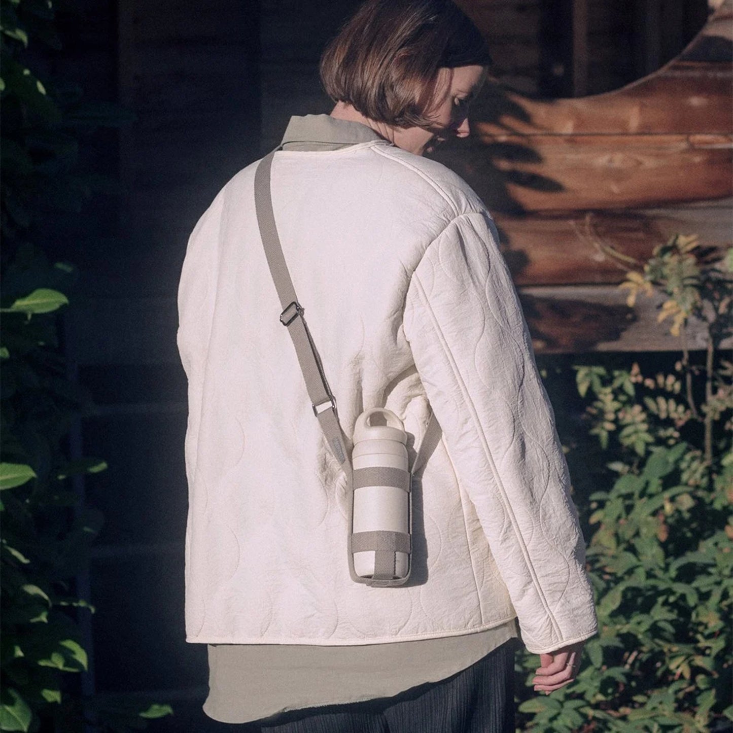 Woman carrying KINTO Tumbler strap medium in Beige holding day off tumbler