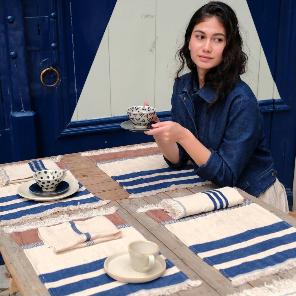Woman holding a teacup in a room with blue and white decor