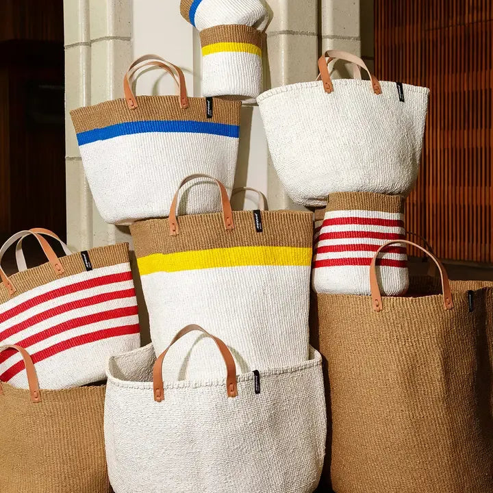 Set of woven bags with colorful stripes against a neutral background