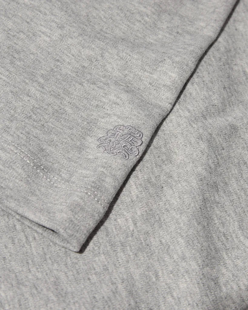 Close-up of the MOS MOSH Gallery Canada Darren Tee in grey melange, showing the soft cotton jersey and the tonal embroidered logo on the sleeve.
