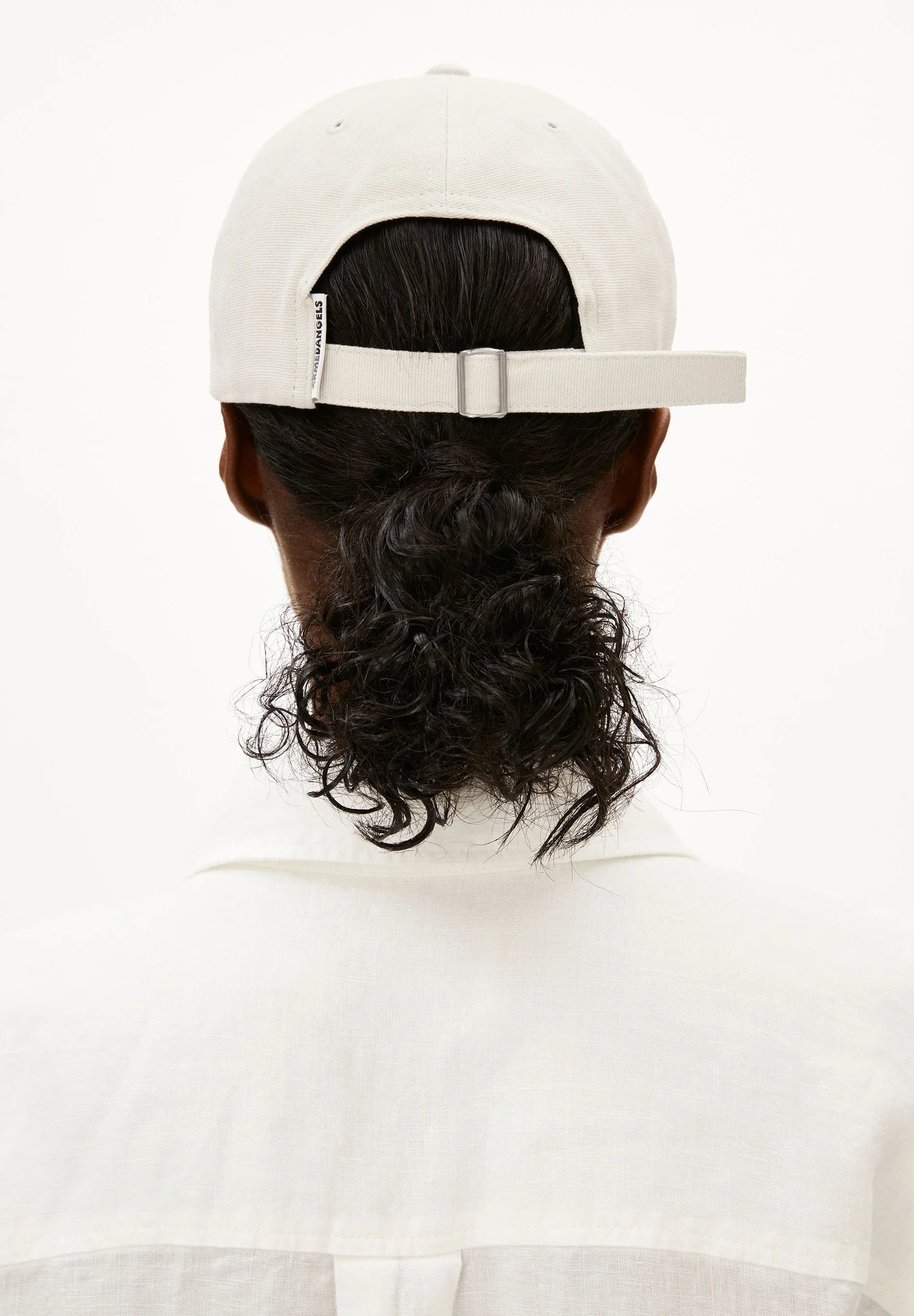 Person wearing a white cap and white shirt on a white background