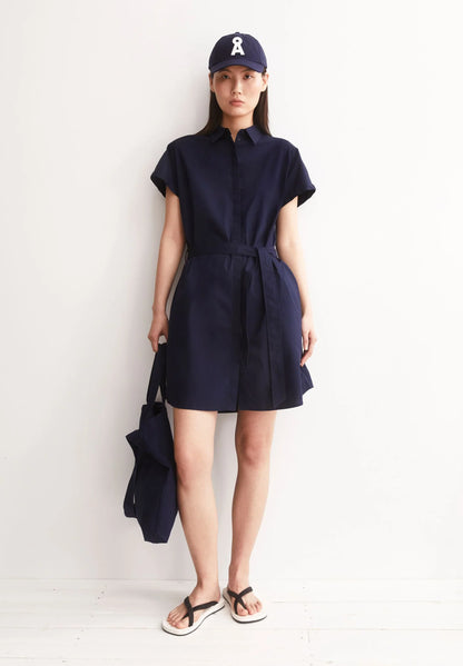 ARMEDANGELS LARISAANA Poplin Mini Dress in Tinted Navy, front studio shot with bag and hat on model in Kelowna, organic cotton