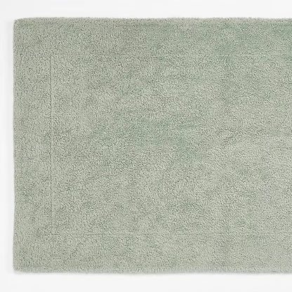 Solid light green bath mat on a white background