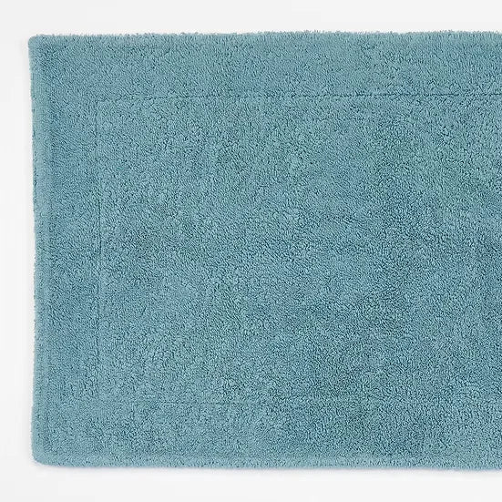 Teal bath mat on a white background