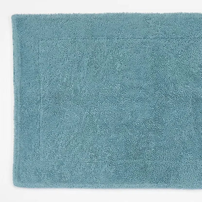 Teal bath mat on a white background