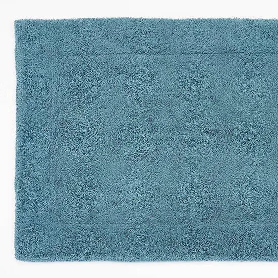Teal bath mat on a white background