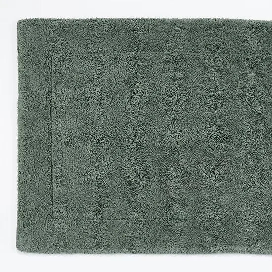 Green bath mat on a white background