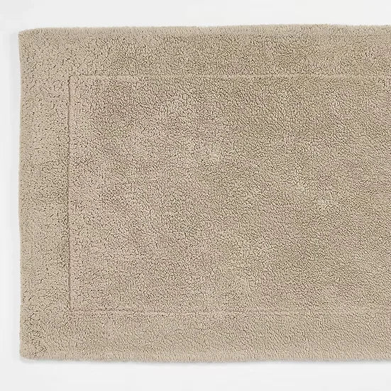 Beige bath mat on a white background