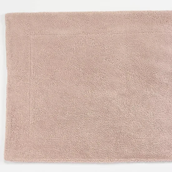 Beige bath mat on a white background