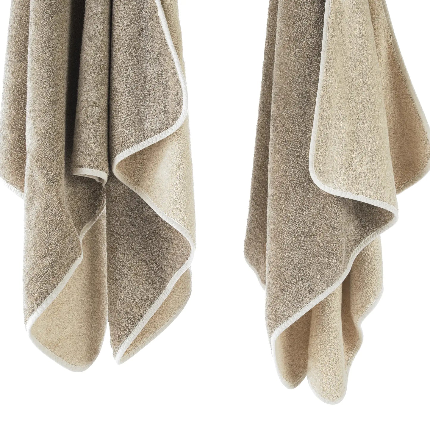 Two beige towels with white edges on a white background