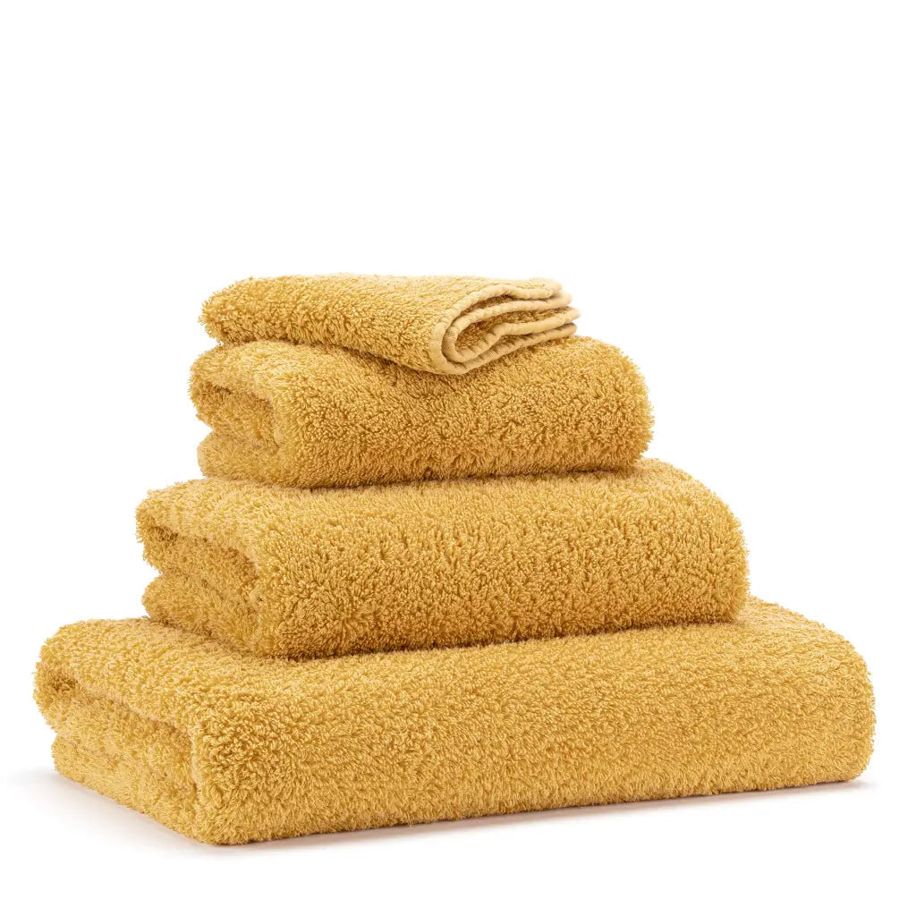 Set of yellow towels stacked on a white background