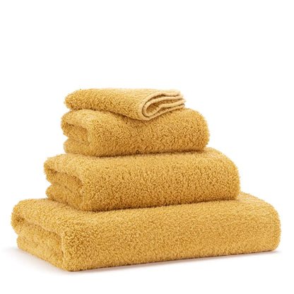 Set of yellow towels stacked on a white background