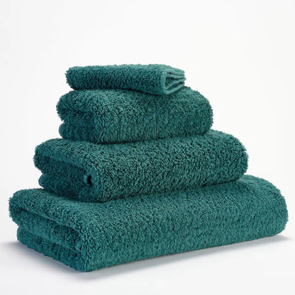 Set of teal towels stacked on a white background