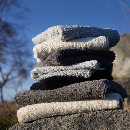 Stack of folded towels on a rock with a blue sky background