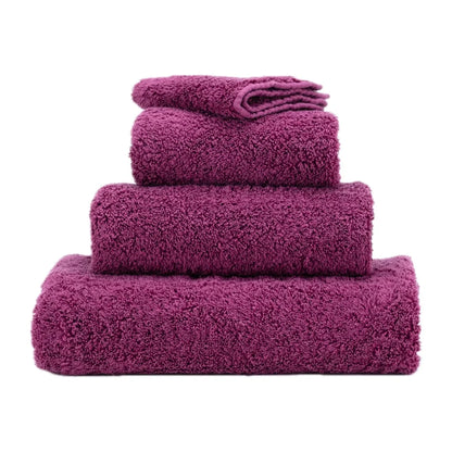 Set of purple towels stacked on a white background
