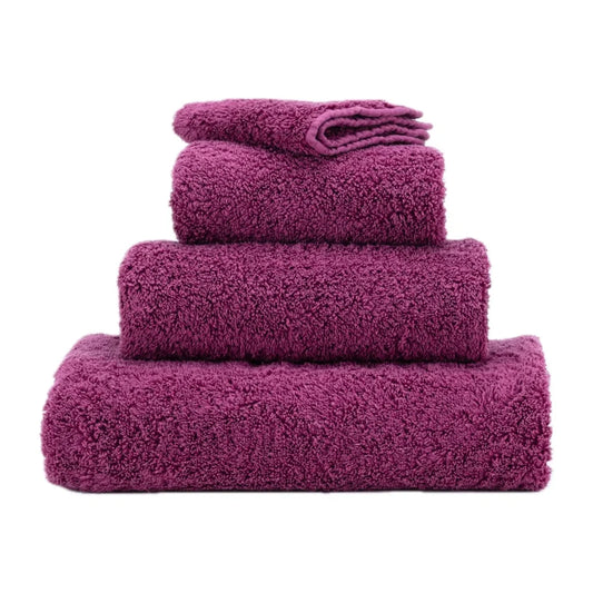 Set of purple towels stacked on a white background
