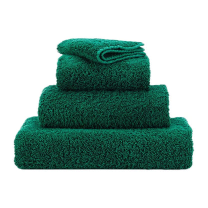 Set of three green towels of different sizes on a white background