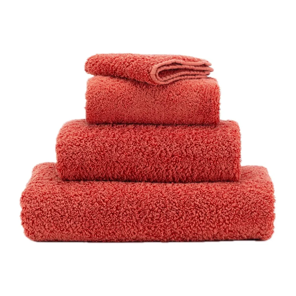 Set of red towels stacked on a white background