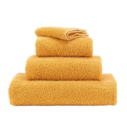 Set of yellow towels stacked on a white background