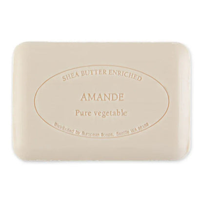 A rectangular bar of Shea Butter Enriched Amande Pure Vegetable soap, featuring a light beige color with embossed text in a circular oval design, shown on a plain white background.