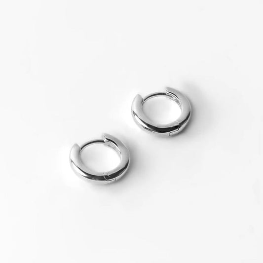 A pair of sterling silver hoop earrings on a white background