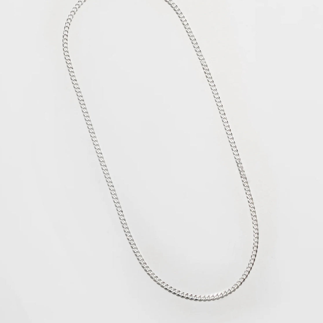 Silver chain necklace on a light gray background
