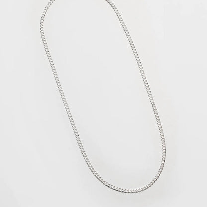 Silver chain necklace on a light gray background
