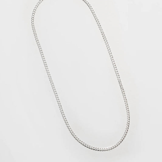 Silver chain necklace on a light gray background