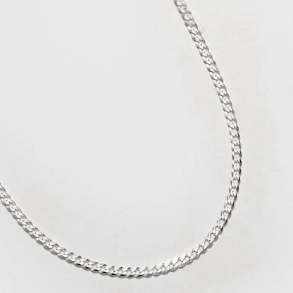 Silver chain necklace on a light gray background
