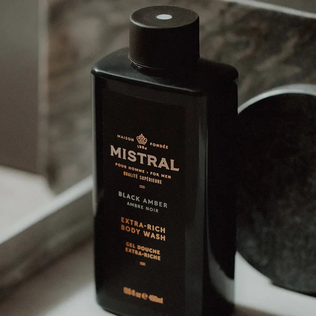 Black bottle of Mistral Black Amber Extra-Rich Body Wash on a marble surface