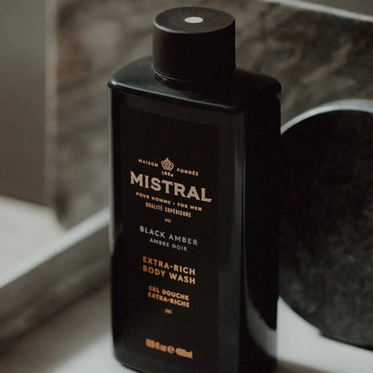Black bottle of Mistral Black Amber Extra-Rich Body Wash on a marble surface