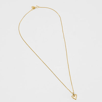 Gold necklace with a heart pendant on a light gray background