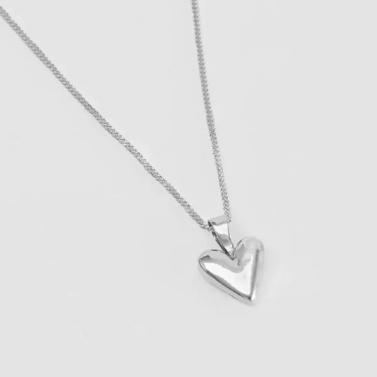 Silver heart-shaped pendant on a chain against a light gray background
