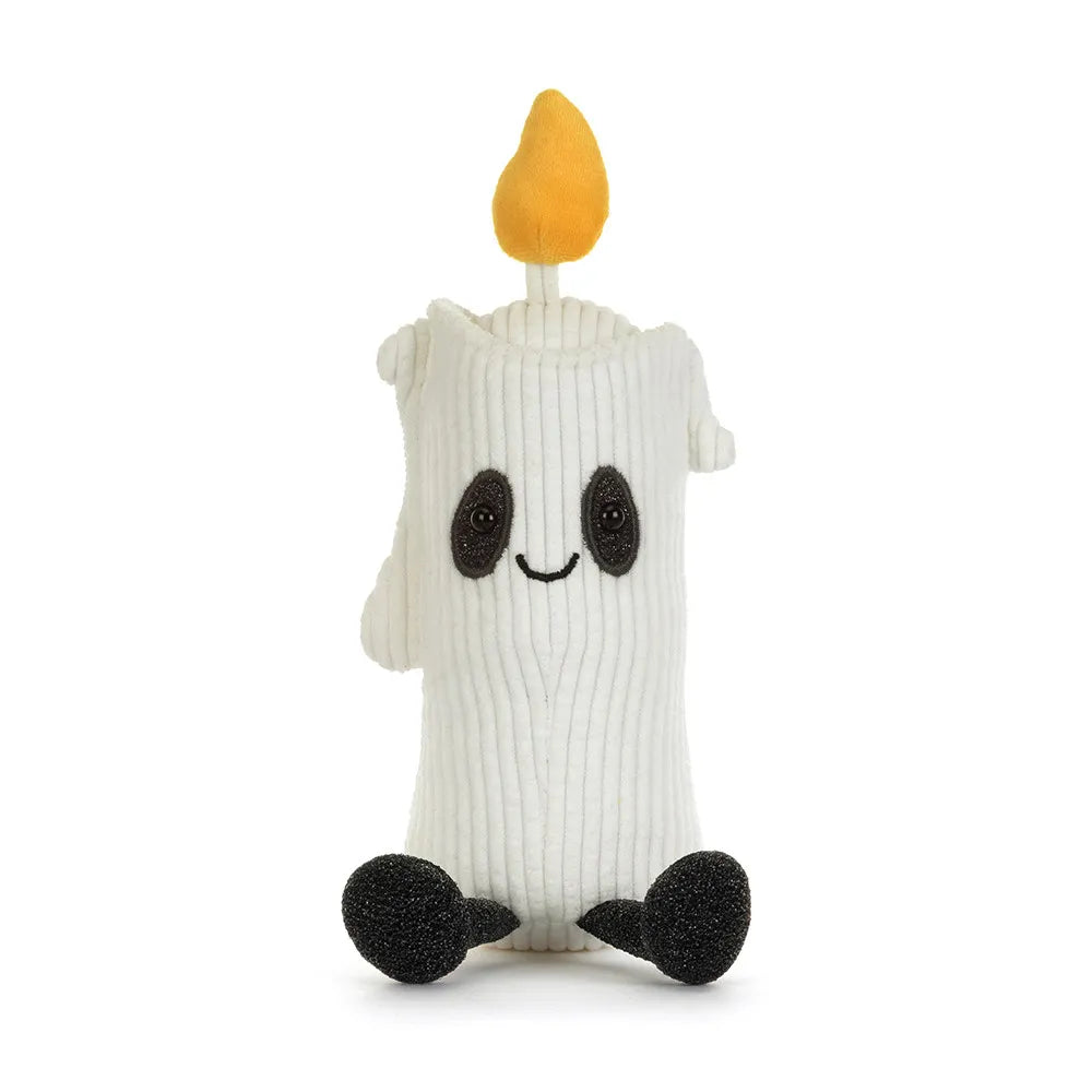 A white ribbed plush toy shaped like a candle with a yellow flame on top, black embroidered eyes and smile, and black feet, shown on a plain white background.