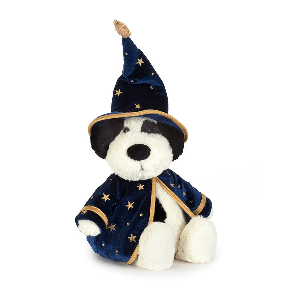 A plush dog stuffed animal dressed as a wizard, featuring a navy blue velvet robe and pointed hat with gold star patterns and trim, set against a plain white background.
