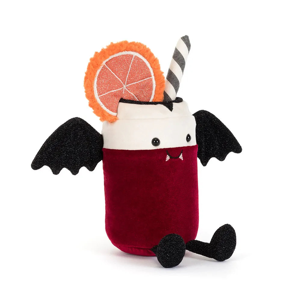 A plush toy shaped like a vampire cocktail in a glass, with a deep red body, white rim, black wings, black feet, a striped straw, and an orange slice decoration on a white background.