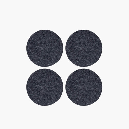 Four dark gray circular coasters on a white background