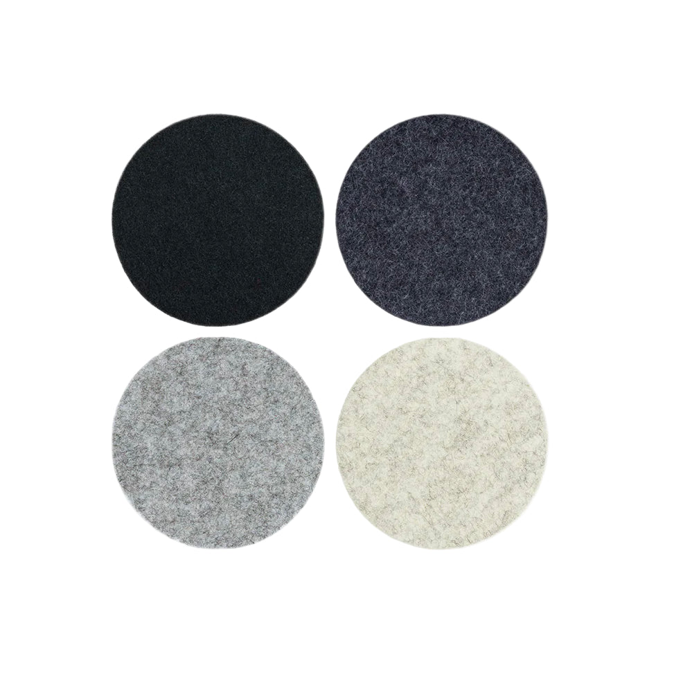 A set of four round coasters in different colors: black, gray, beige, and white, displayed against a white background.
