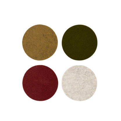 A set of four round coasters in different colors: red, green, brown, and white, made from merino wool felt.