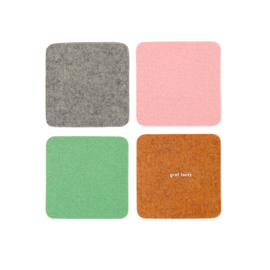 Four square coasters in gray, pink, green, and brown with 'graf lantz' branding on a white background.