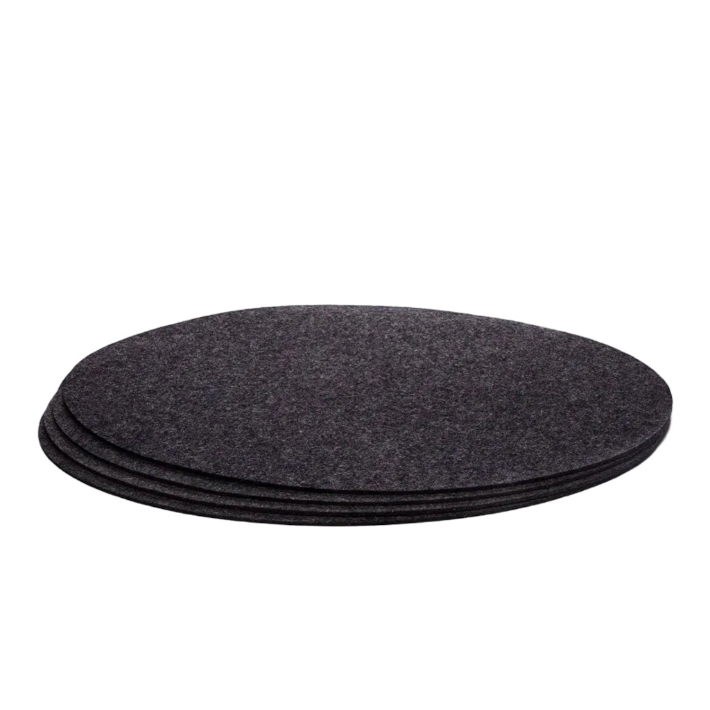A set of four charcoal gray Merino wool felt placemats stacked on top of each other.