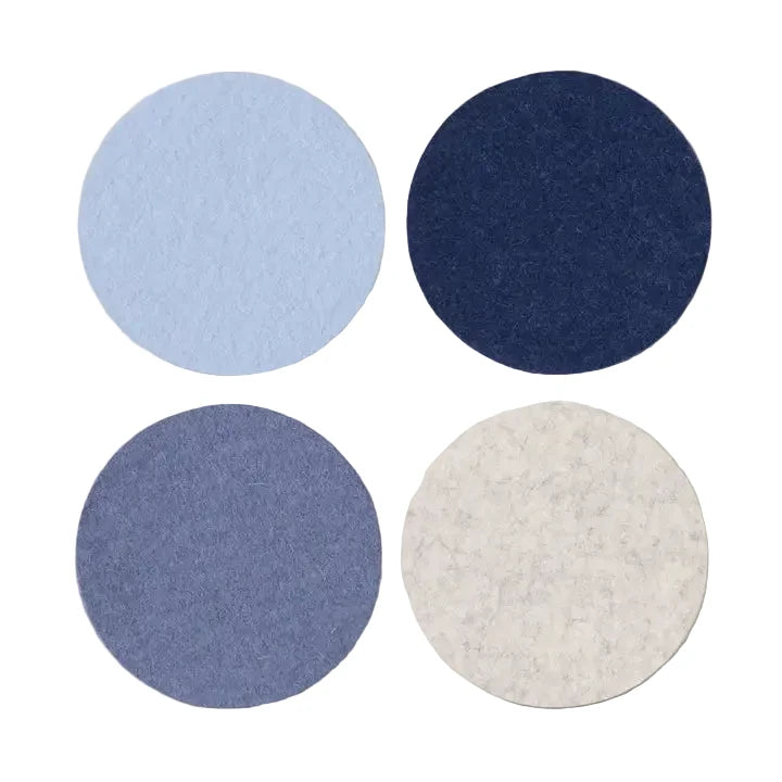 Four round coasters in blue, gray, and navy on a light gray background