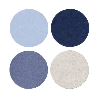 Four round coasters in blue, gray, and navy on a light gray background