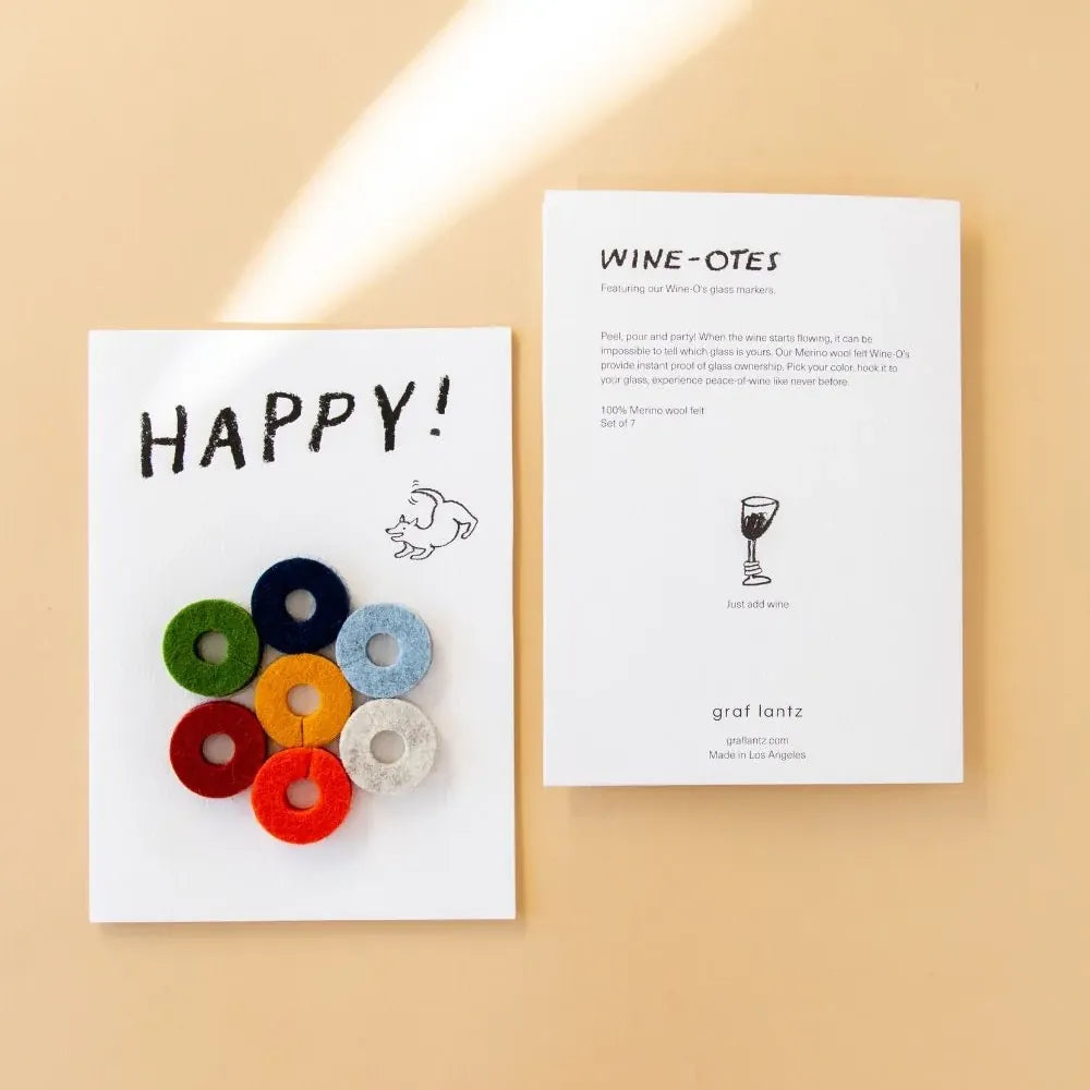 Colourful circular wine markers on a card with 'HAPPY!' text, next to a 'WINE-OTES' card on a beige background.