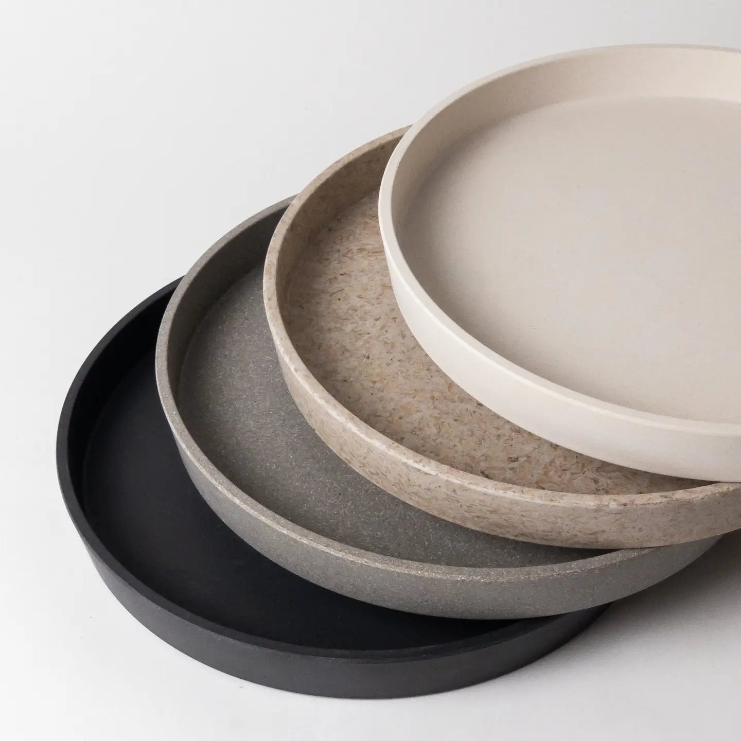 Round bamboo fibre trays on a light gray background
